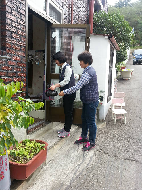 독거노인에게 도시락을 전달하고 있는 봉사단 사진