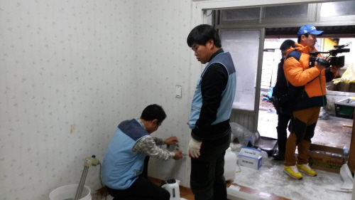 촬영중인 카메라와 콘센트를 수리중인 봉사단