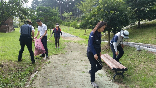 시민공원을 찾아가 산책로 주변쓰레기 줍기 환경정화하는 장면
