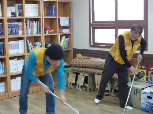울산사업소 나누리 봉사단 중 2명이 바닥을 청소하고 있는 사진