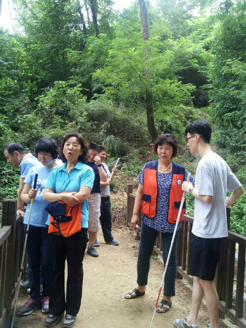새빛맹인선교원 맹인들과 봉사단이 산책로에서 얘기중인 사진