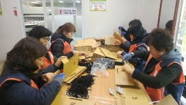 신애재활원을 방문, 지체장애인과 포장만들기 하는 모습